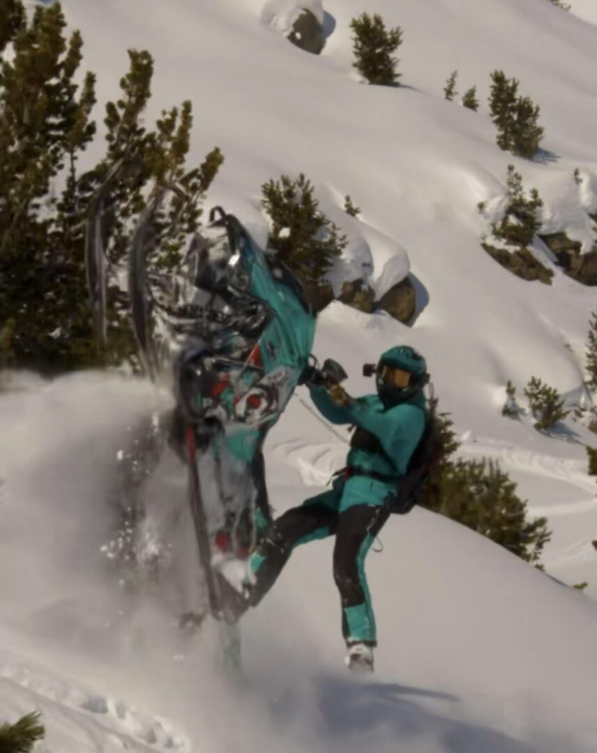 A man doing a stunt with a green color sled